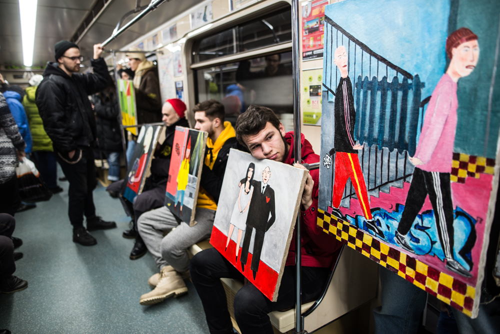 Белорусский художник сделал выставку в вагоне метро, одну из картин держит Бакей