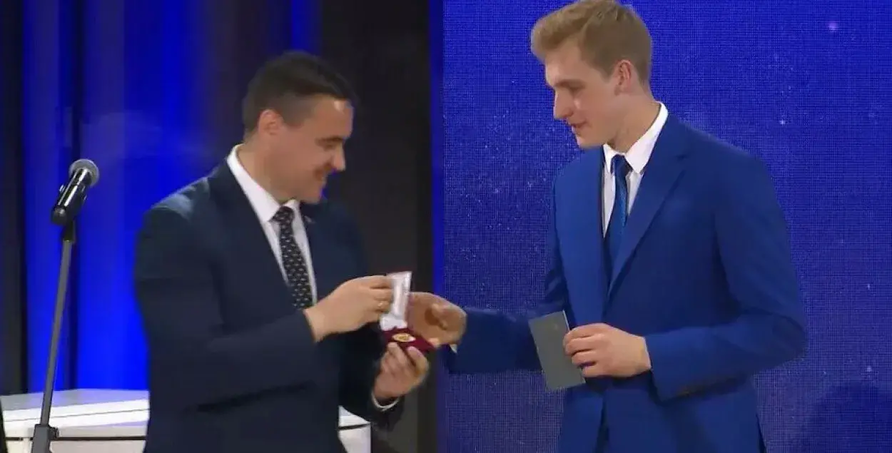 Николай Лукашенко (справа) на выпускном получает медаль из рук министра образования Андрея Иванца (слева)