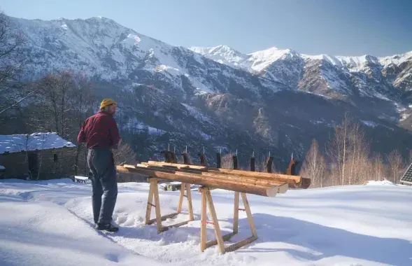 Мужчина снимает на видео ремонт дома в Альпах