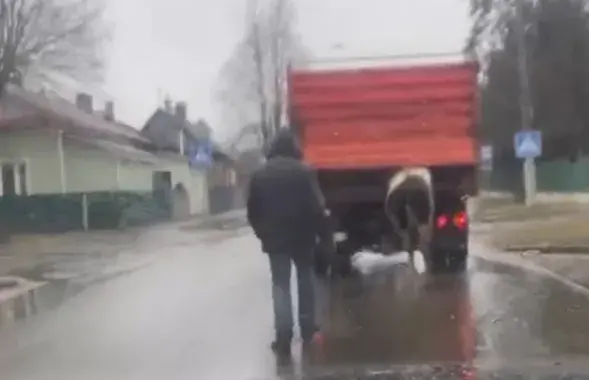 Случайный прохожий шел с палкой за автомобилем
