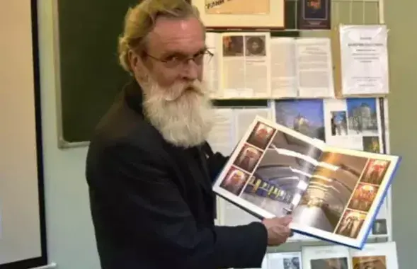 Валерий Чайка держит в руках альбом со снимками станции метро"Институт культуры". Он работал над ее оформлением
